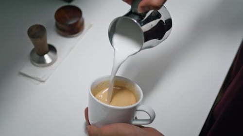 Milk Being Poured into Espresso Drink on Counter