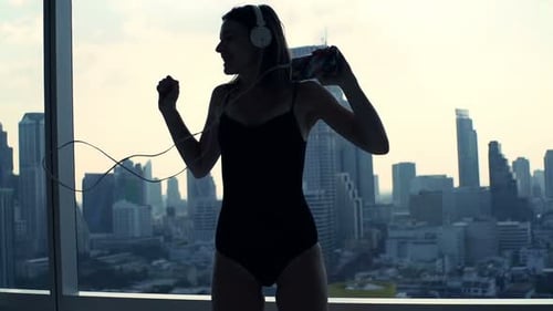 Woman Dancing with Headphones in Urban Apartment