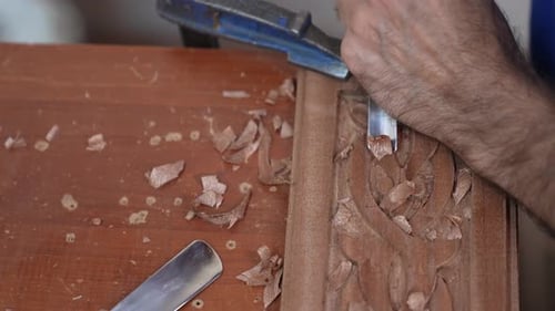 Woodworker Carving Floral Design on Wooden Board Close-up