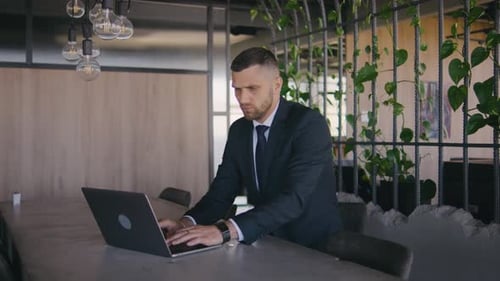 Male Businessman Working in a Modern Office at a Laptop Portrait of a Male Boss in a Formal Suit A