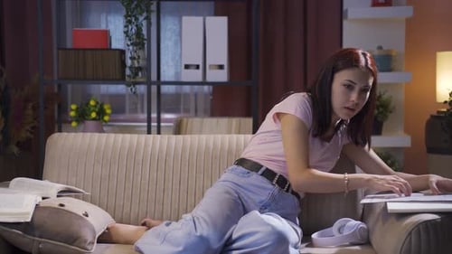 Tired Woman Studying on Sofa at Night