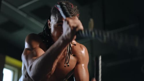Man Exercising with Battle Ropes at the Gym