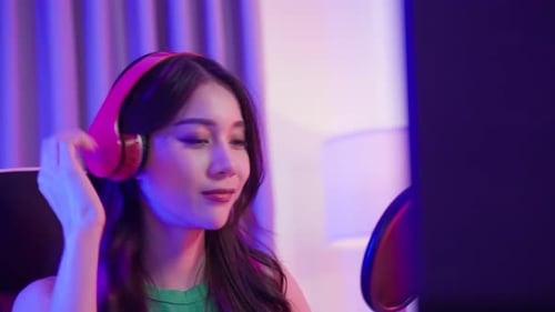 Woman Sings into Microphone with Pink Headphones