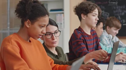 Students Using Laptops in Classroom with Teacher