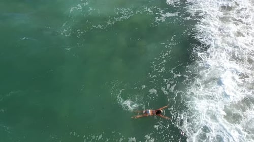 Aerial View of a Woman Swimming in the Sea by Drone