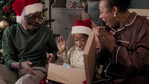 Family Opens Christmas Present in Pajamas and Hats