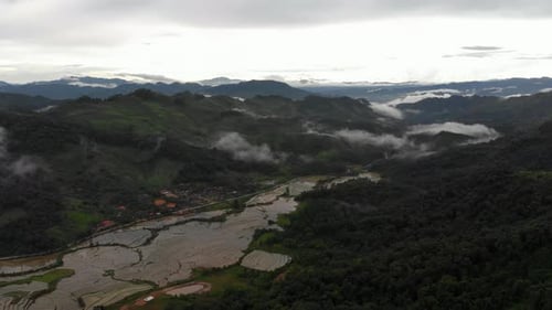 Imagens de alta altitude em 4K de voo sobre um lindo vale com arrozais em um vale sereno