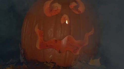 Halloween Pumpkin Jack O Lantern on black background with billowing smoke