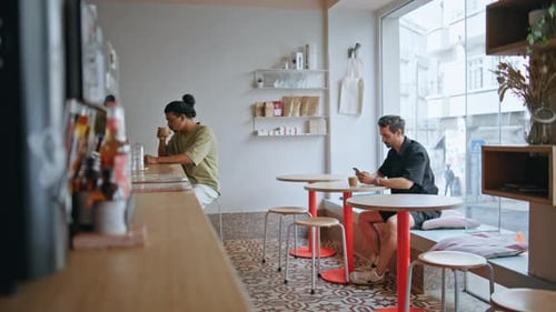 Young Adults in Modern Cafe with Technology