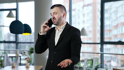 Man in Suit Talking on Cell Phone Indoors
