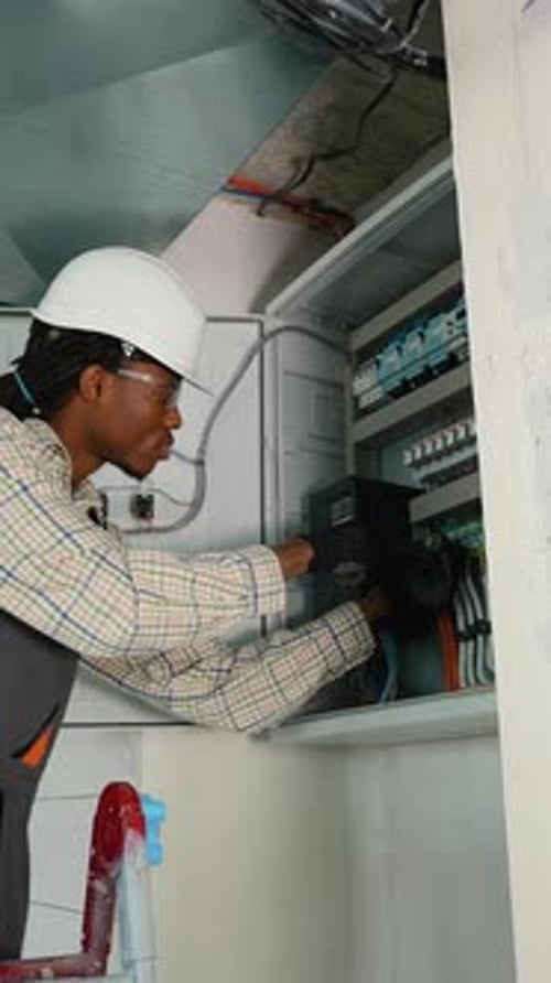 Electrician Installing Surge Protector in Electrical Panel