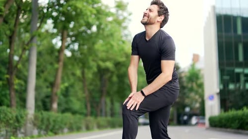 Man Experiencing Knee Pain on Sidewalk