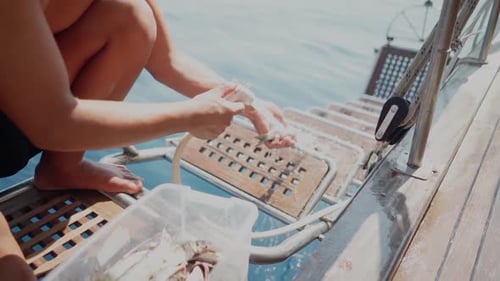 Man Washing Fish with Water Sprayer on Boat