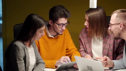 Office Workers Discuss Startup Project in Conference Room with Charts Laptop Tablet Employees