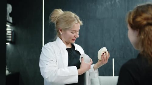 Overtheshoulder Shot of Doctor Applying Breast Implant in Front of Patient