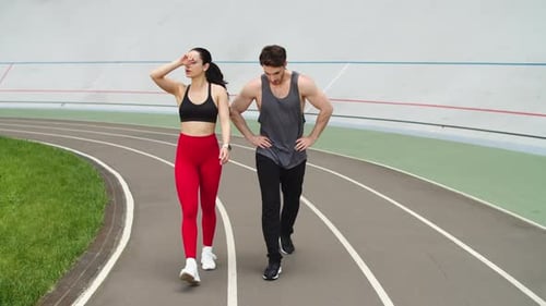 Fit Couple Walking Together on Track After Workout