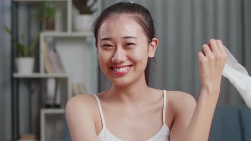 Close Up Of Beautiful Young Asian Woman Taking Off Sheet Facial Mask And Smiling To Camera