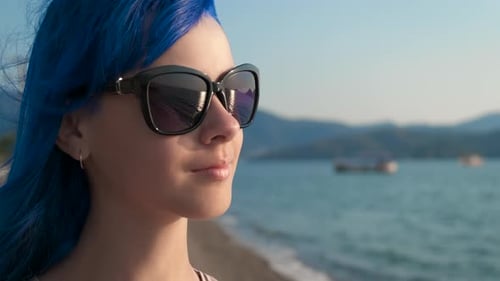 Portrait of a young girl in sunglasses on the beach.