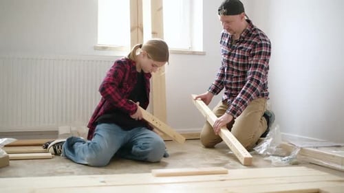 Père et fille regardant le schéma d'assemblage des meubles