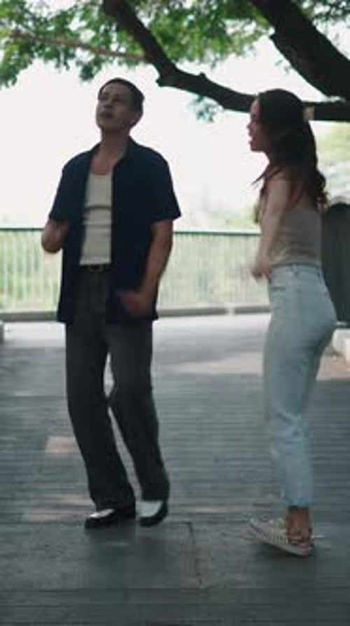 Couple Dancing Playfully Moving Together with Energy and Happiness in Green Urban Space