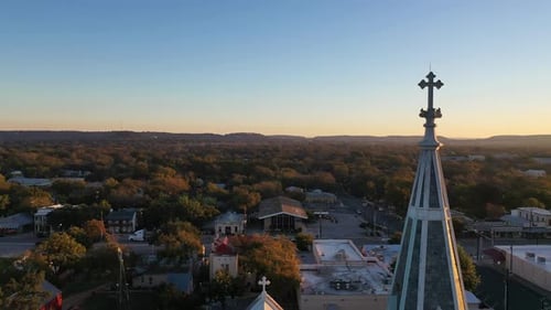 Gothic cathedral religious chapel structure in suburban neighborhood, aerial descend at sunset
