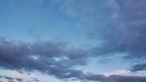 Bewegte Wolken am blauen Himmel nach Sonnenuntergang