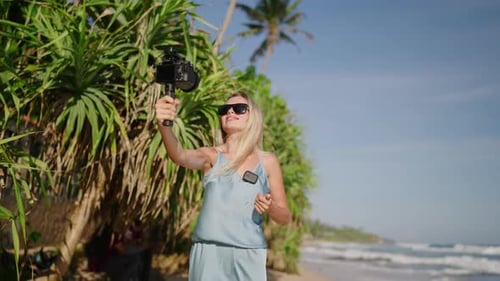 Woman Travel Blogger Enjoys Hot Summer Filming Herself on Camera at Tropical Island with Palm Trees