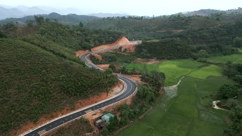 Newly Paved Curved Road Without Traffic Between the Forests and Mountains of Vietnam