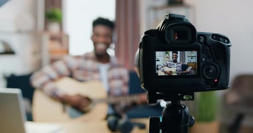 View Through Camera Lens Where Likable Smiling Happy Young Blackskinned Male Guitarist Enjoying His