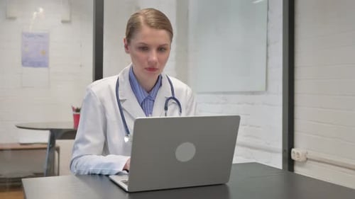Doctor Working on Laptop in Modern Office