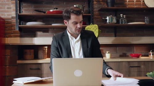 A Business Professional Works on a Laptop in a Modern Office Focusing on Career Tasks
