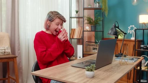 Excited Woman Opening Laptop and Celebrating Success Indoors