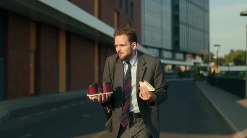Rushed Office Worker Eats Sandwich While Hurrying to Work