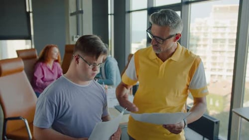 Inclusive Team Discussing Paperwork in Modern Office