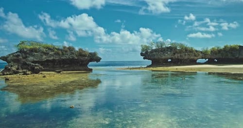 Aerial view of coral reef reflection on the seashore, bright blue sky