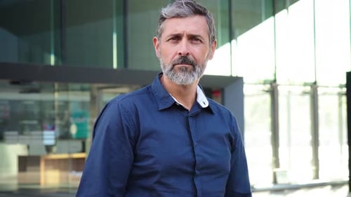 Confident Mature Man with Crossed Arms Stands Proudly