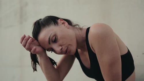 Woman Resting After Intense Workout in Urban Setting