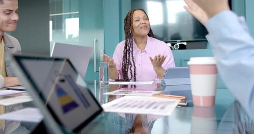 Smiling woman in meeting, discussing business strategy with colleagues in office