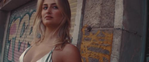 Blonde Model Posing by Graffiti Wall in City