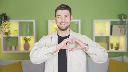 Smiling Man Makes Heart Shape With Hands