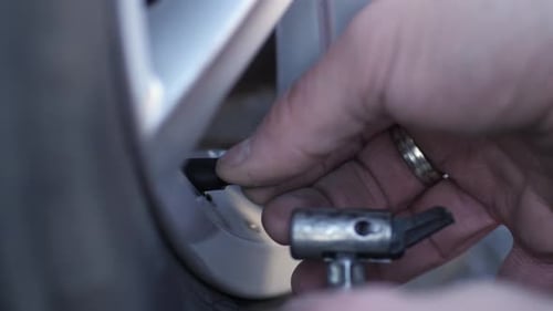 Le mécanicien connecte un tuyau de pompe fin avant de commencer le processus de gonflage des pneus