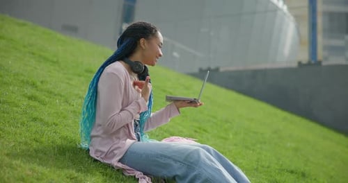 Woman Video Conferencing on Laptop in Urban Park