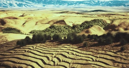 Vast Desert Landscape with Undulating Sand and Distant Mountains at Sunset