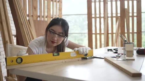 Carpenter is working at woodshop.