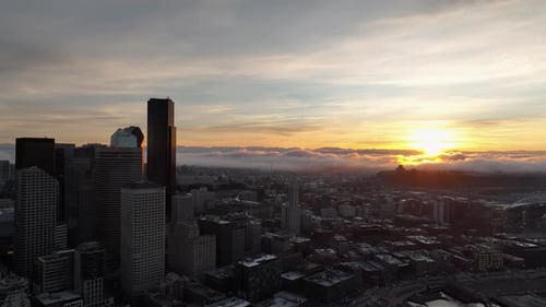 Seattle skyscrapers and cityscape with a golden sunrise and fluffy clouds