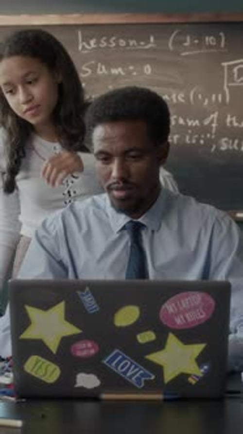 Vertical of Male Teacher Explaining Software Engineering Topic to Schoolgirl