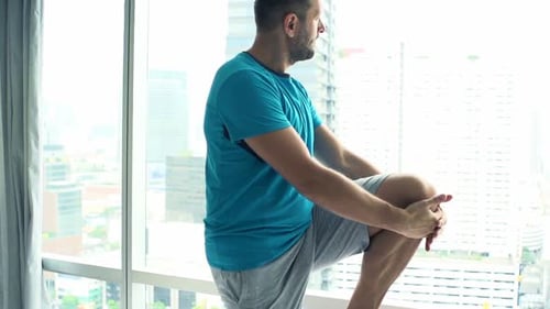 Sporty Man Exercising, Stretching Legs by Window in Gym, Super
