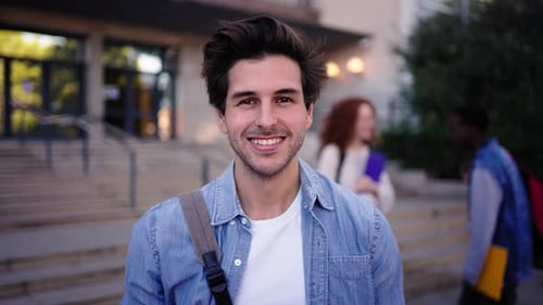 Portrait of Young Caucasian Man Student Looking Smiling at Camera in Front of a University Building