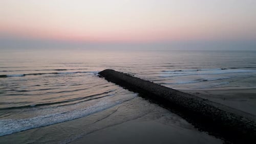 Luftbild — Steinpier, der sich bei Sonnenaufgang ins ruhige Meer erstreckt