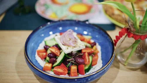 Salade grecque colorée avec fromage feta, tomates, concombres, olives et oignons rouges servie dans un bol